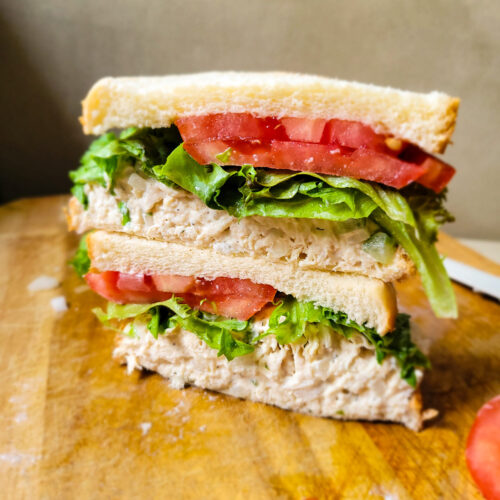 Chicken salad recipe made into a sandwich with lettuce and tomato.